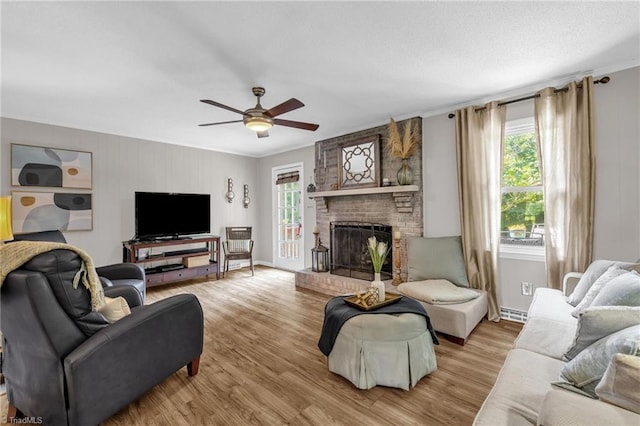8194 Brotherstwo Rd, Colfax, NC 27235 - living room featuring ceiling fan, light wood-style flooring, a fireplace, and ornamental molding