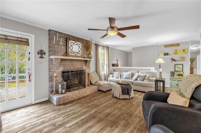 8194 Brotherstwo Rd, Colfax, NC 27235 - living room featuring crown molding, a ceiling fan, light wood-style flooring, and a brick fireplace