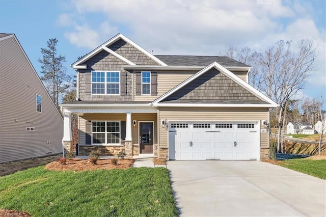 craftsman-style house featuring a garage, a porch, and a front yard