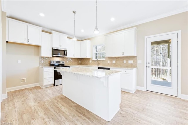 kitchen with appliances with stainless steel finishes, light stone counters, decorative light fixtures, a center island, and white cabinetry