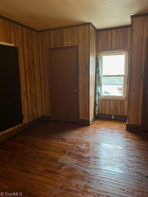 spare room with dark hardwood / wood-style floors and wood walls