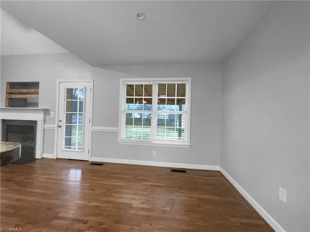 unfurnished living room with a fireplace with flush hearth, visible vents, baseboards, and dark wood-style flooring