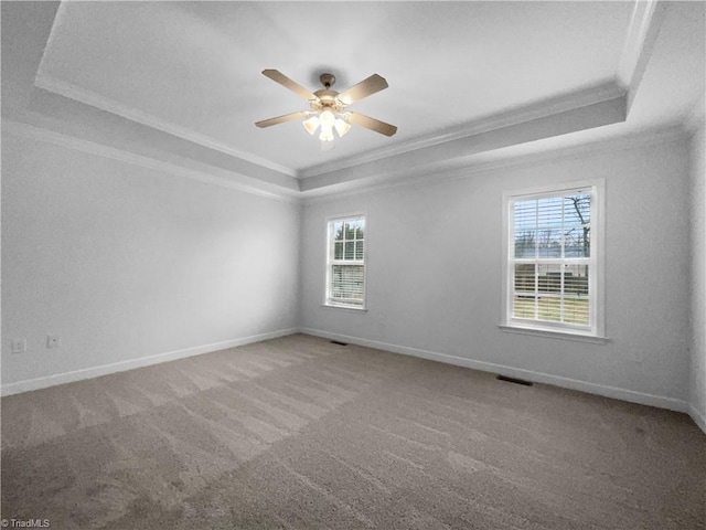 spare room with ornamental molding, carpet, a raised ceiling, and baseboards