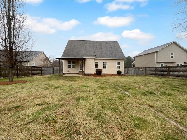 rear view of property with a fenced backyard, a yard, and a patio