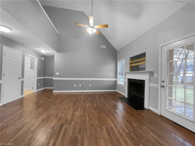 unfurnished living room with baseboards, dark wood-style floors, a fireplace with flush hearth, ceiling fan, and high vaulted ceiling