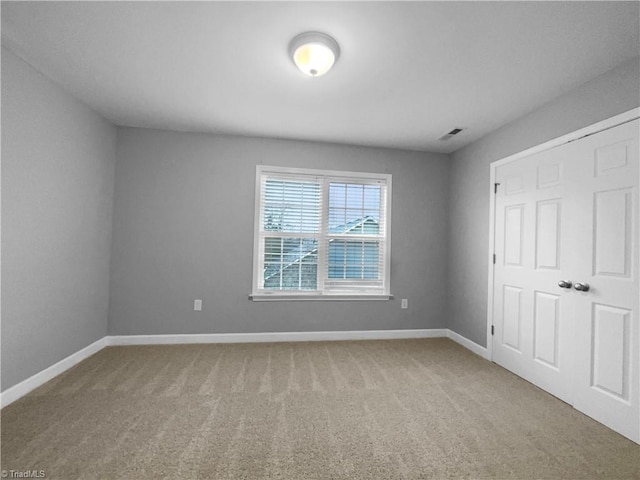 unfurnished bedroom featuring carpet flooring, visible vents, and baseboards