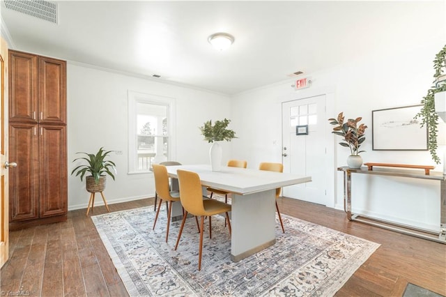 dining area with ornamental molding and hardwood / wood-style floors