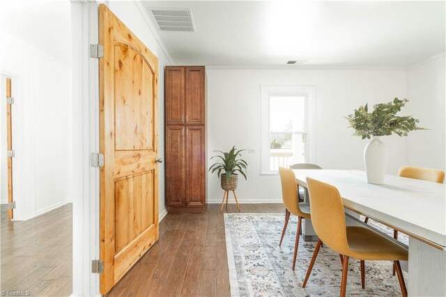 dining room with ornamental molding and wood-type flooring