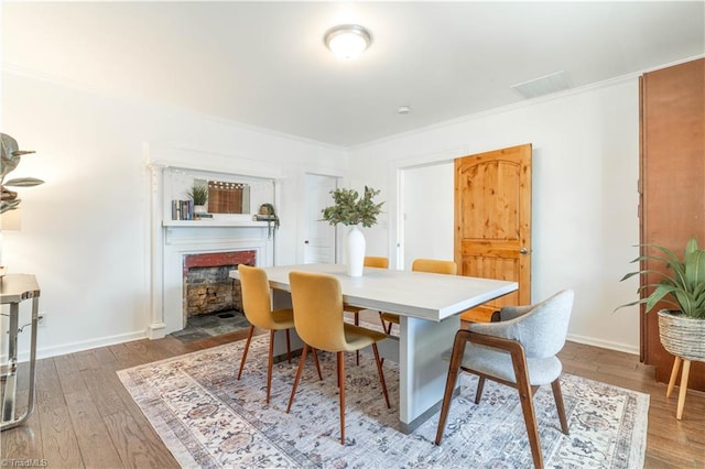 dining area with ornamental molding and wood-type flooring