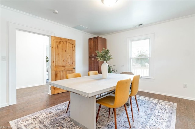 dining area featuring crown molding and hardwood / wood-style floors