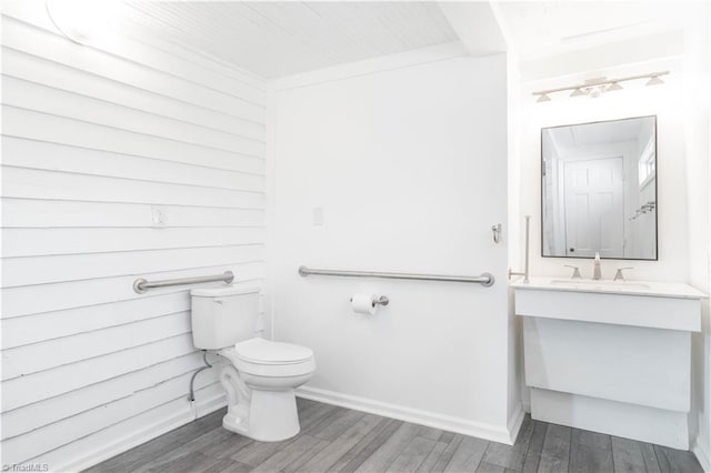 bathroom with hardwood / wood-style flooring, toilet, and vanity with extensive cabinet space