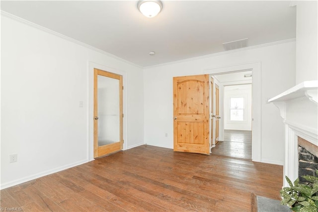 unfurnished living room with wood-type flooring, a fireplace, and crown molding