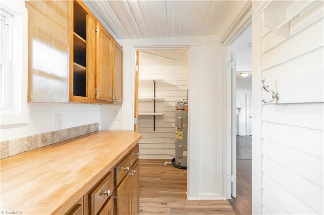 kitchen featuring butcher block countertops, light hardwood / wood-style flooring, and water heater