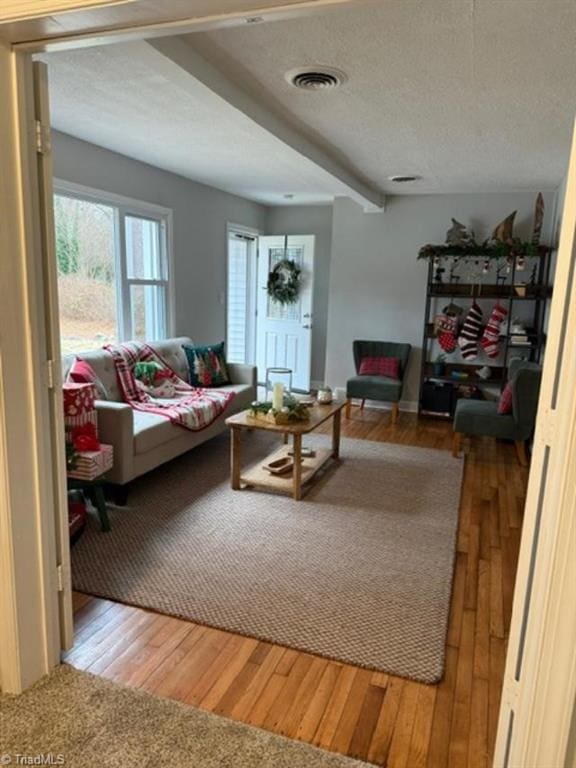 living room with hardwood / wood-style floors and beam ceiling