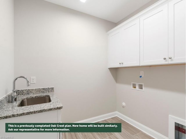 laundry area featuring washer hookup, cabinet space, light wood-style floors, a sink, and baseboards