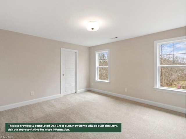 carpeted spare room featuring baseboards