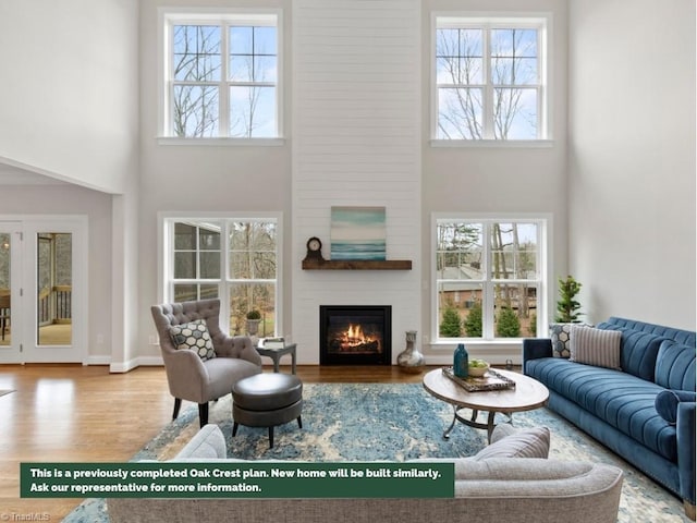 living room featuring plenty of natural light, a fireplace, and wood finished floors