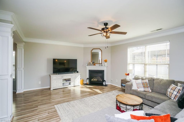 living room featuring light hardwood / wood-style flooring, ceiling fan, and ornamental molding