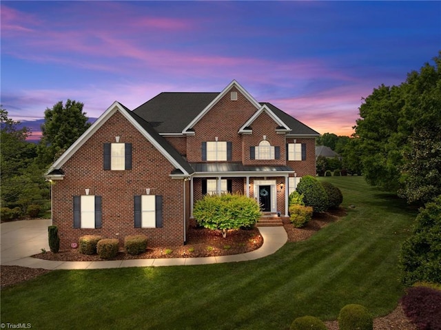 view of front facade with brick siding and a front yard