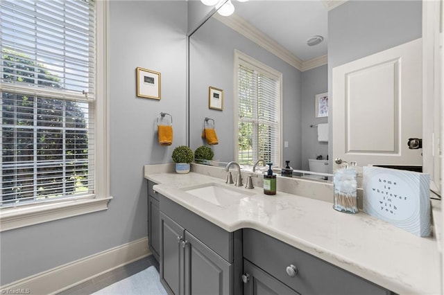 bathroom featuring vanity, baseboards, crown molding, and a healthy amount of sunlight