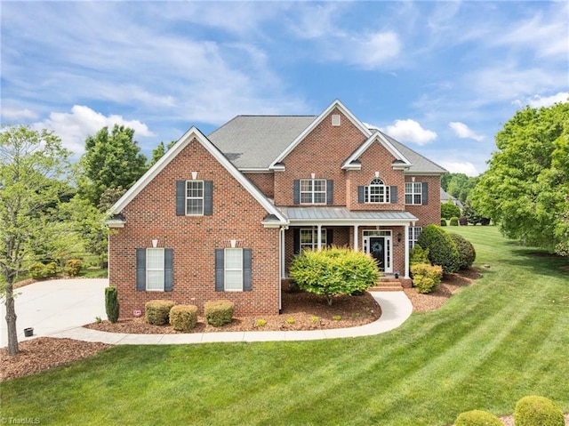 view of front of home featuring brick siding, a front yard, and a porch