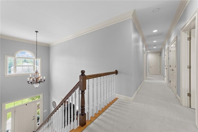 hallway featuring crown molding, a notable chandelier, baseboards, an upstairs landing, and visible vents
