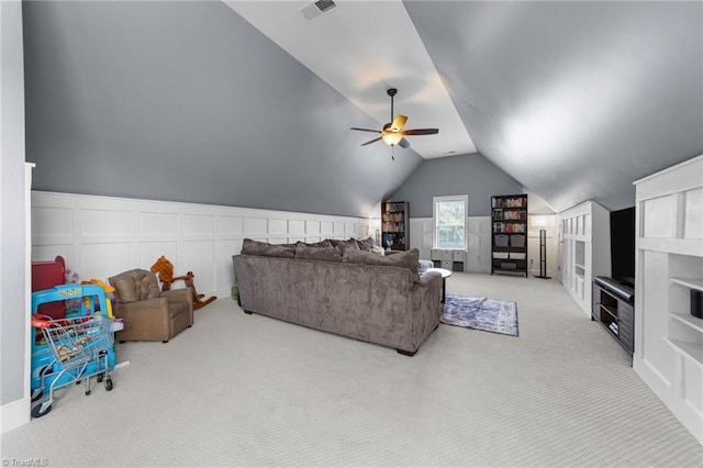 living room with vaulted ceiling, visible vents, carpet, and a decorative wall