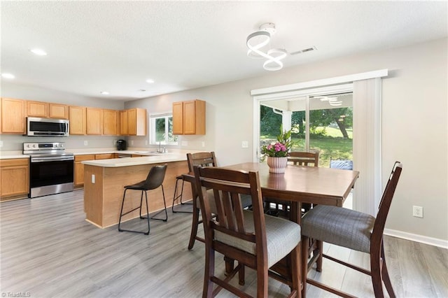3602 Turquoise Dr, Durham, NC 27703 - dining room with light wood finished floors, a chandelier, recessed lighting, and baseboards
