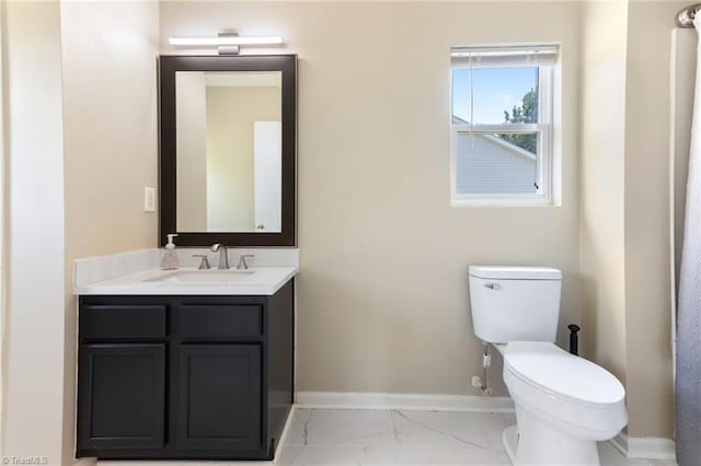 3602 Turquoise Dr, Durham, NC 27703 - bathroom with marble look tiles, toilet, vanity, and baseboards
