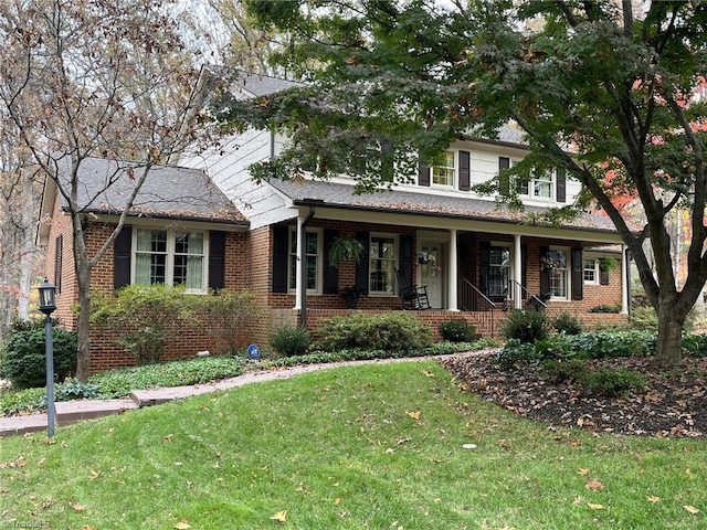 view of front of property featuring a front yard and covered porch