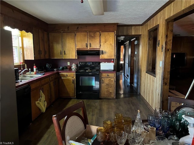 kitchen with wood walls, ventilation hood, dark hardwood / wood-style flooring, ornamental molding, and black appliances