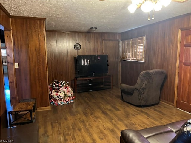 living room featuring a textured ceiling, dark hardwood / wood-style flooring, and wood walls