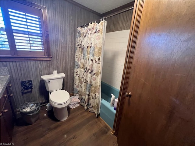 full bathroom featuring shower / bath combination with curtain, hardwood / wood-style flooring, vanity, ornamental molding, and toilet