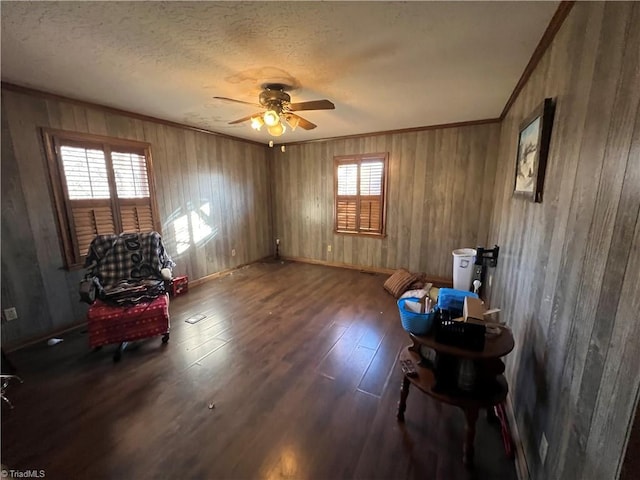 sitting room with ceiling fan, ornamental molding, dark hardwood / wood-style floors, and a textured ceiling