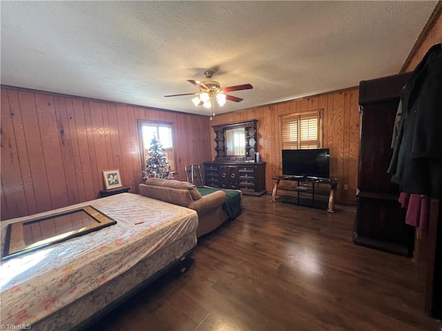 bedroom with multiple windows, ceiling fan, dark wood-type flooring, and a textured ceiling