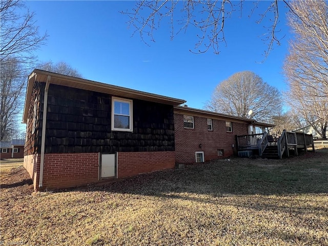 view of side of property featuring a yard and a deck