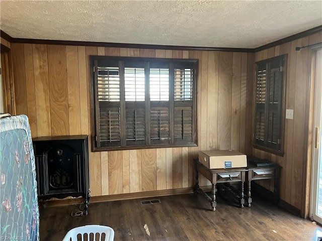 sitting room with dark hardwood / wood-style floors, a textured ceiling, and wooden walls