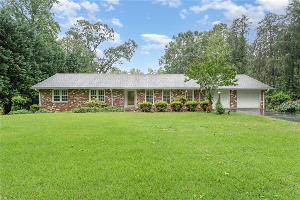 3980 Philpark Dr, Winston-Salem, NC 27106 - ranch-style house with a garage, a front lawn, driveway, and brick siding