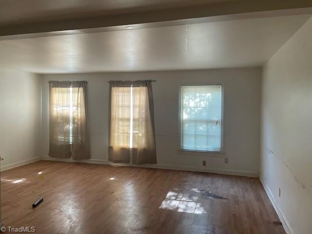 2821 Bleeker Sq Unit C, Winston-Salem, NC 27106 - spare room with healthy amount of natural light, wood finished floors, and baseboards