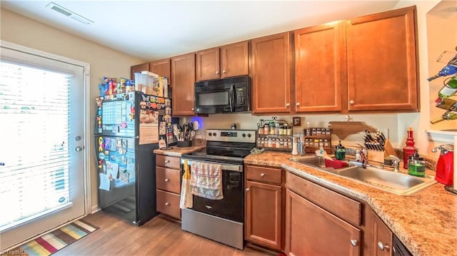 104 Tilleys Grove Dr, Kernersville, NC 27284 - kitchen with black appliances, light wood-style flooring, light countertops, and brown cabinetry