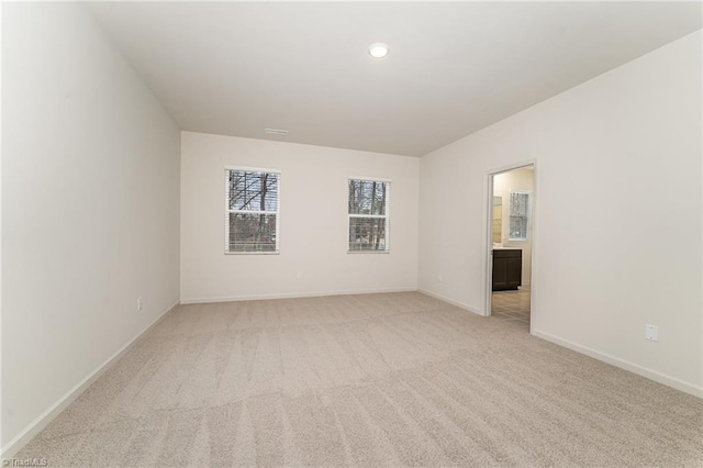 unfurnished room featuring light carpet