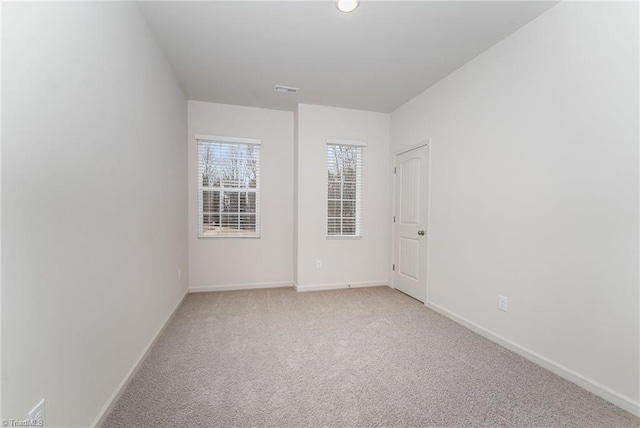 spare room featuring light colored carpet