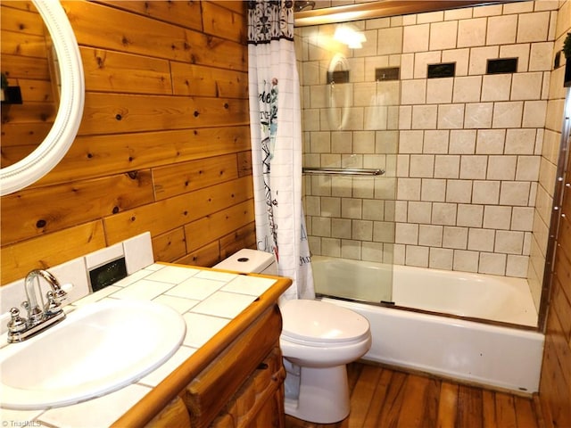 full bathroom featuring vanity, shower / bath combination with curtain, wooden walls, hardwood / wood-style flooring, and toilet