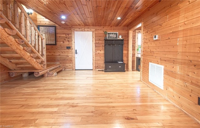 foyer entrance featuring wooden walls, wooden ceiling, and light wood-type flooring