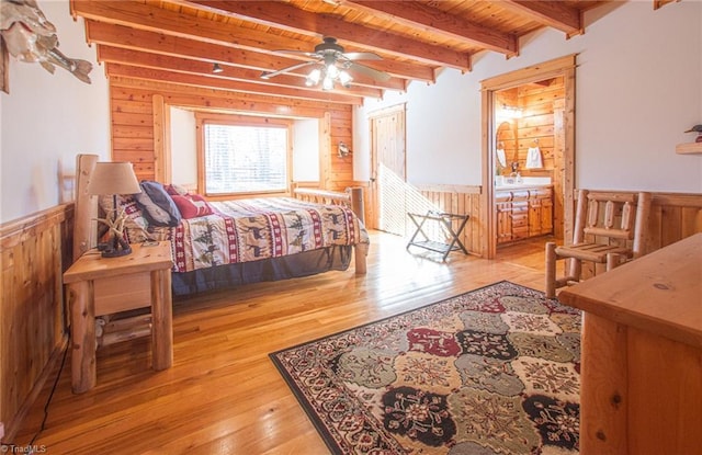 bedroom with beamed ceiling, light wood-type flooring, wooden ceiling, and wood walls