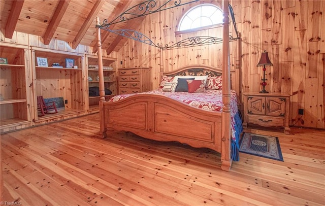 unfurnished bedroom featuring vaulted ceiling with beams, light wood-type flooring, wood ceiling, and wood walls