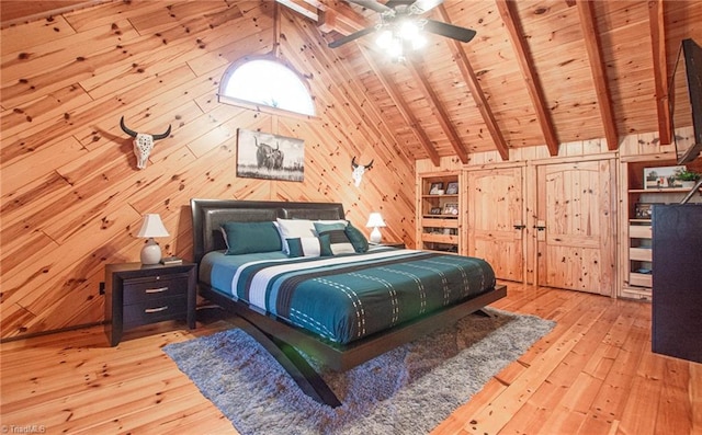 bedroom featuring ceiling fan, wooden ceiling, vaulted ceiling with beams, light hardwood / wood-style floors, and wooden walls