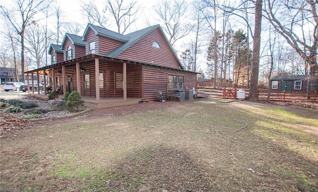 view of side of property with a yard and central AC