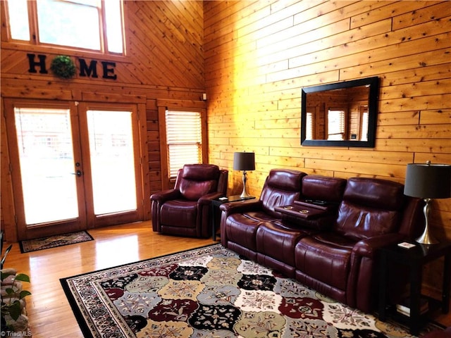 living room featuring french doors, a high ceiling, and light wood-type flooring