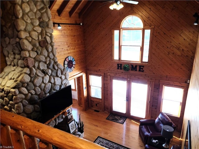 living room with beam ceiling, hardwood / wood-style floors, high vaulted ceiling, and french doors